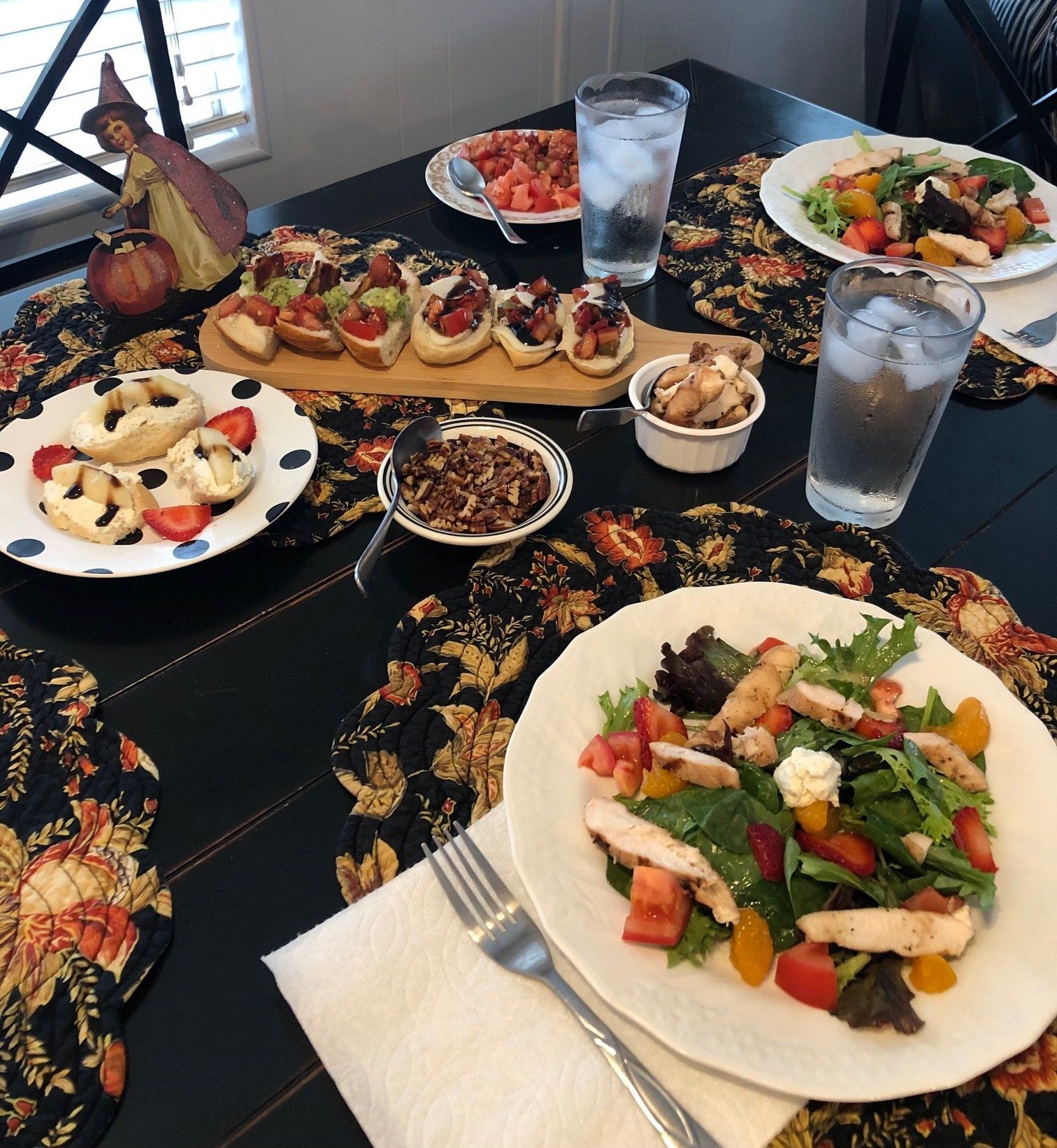 A table topped with plates of food including a salad