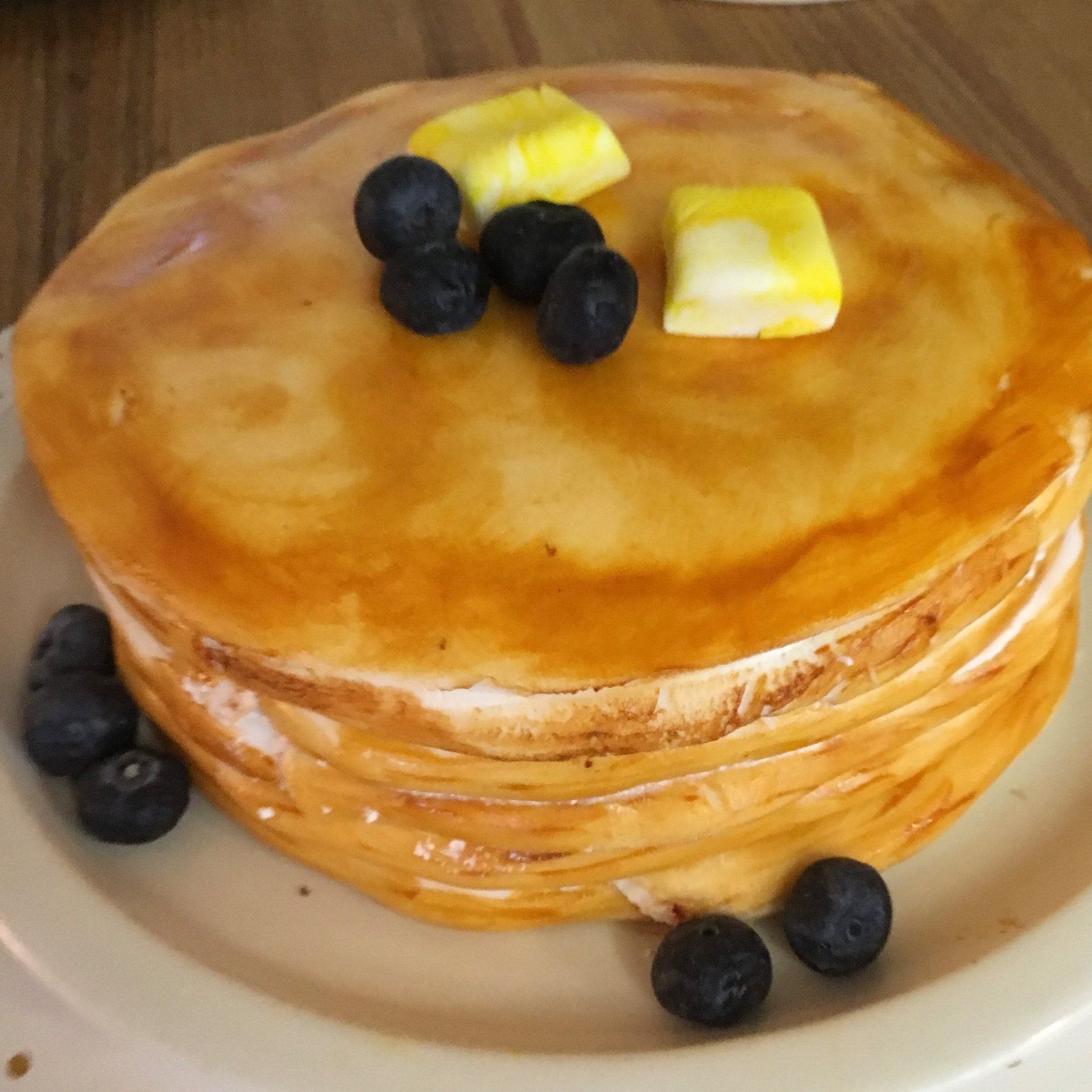 A stack of pancakes with blueberries and butter on top