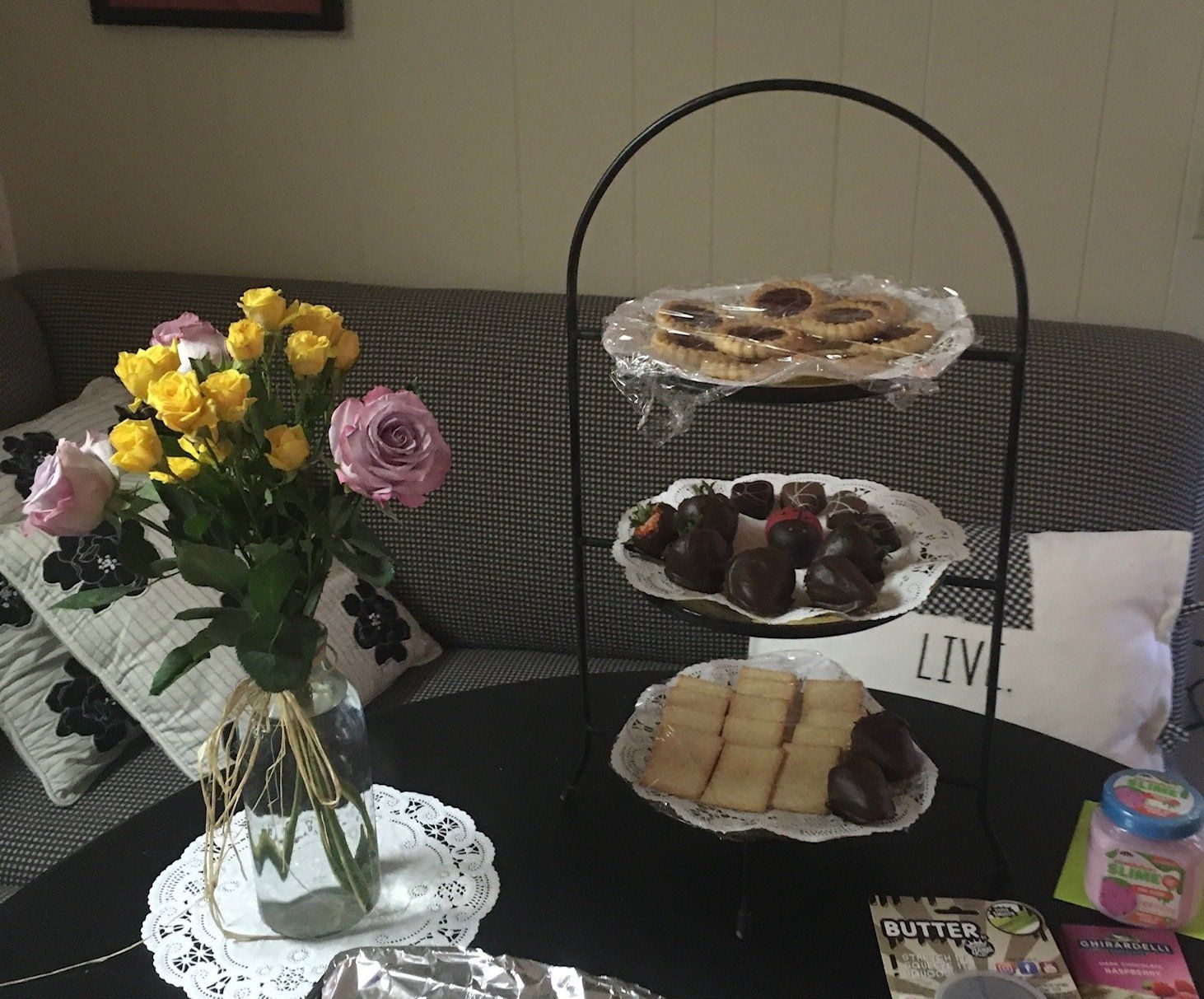 A table with plates of food and a vase of flowers on it