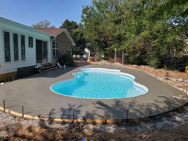 A swimming pool is being built in the backyard of a house.