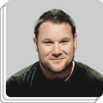 A man with a beard is smiling and wearing a black shirt
