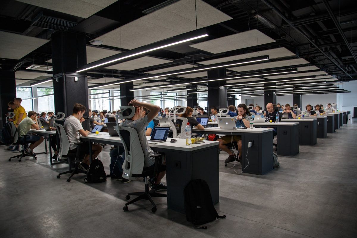 A group of people are sitting at desks in an office.