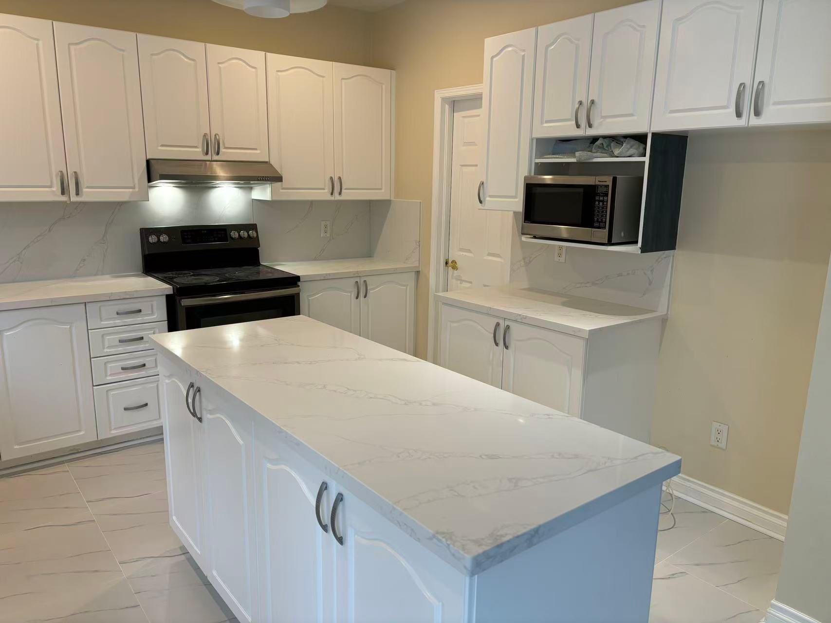 White kitchen cabinets with quartz countertops and island in London, Ontario