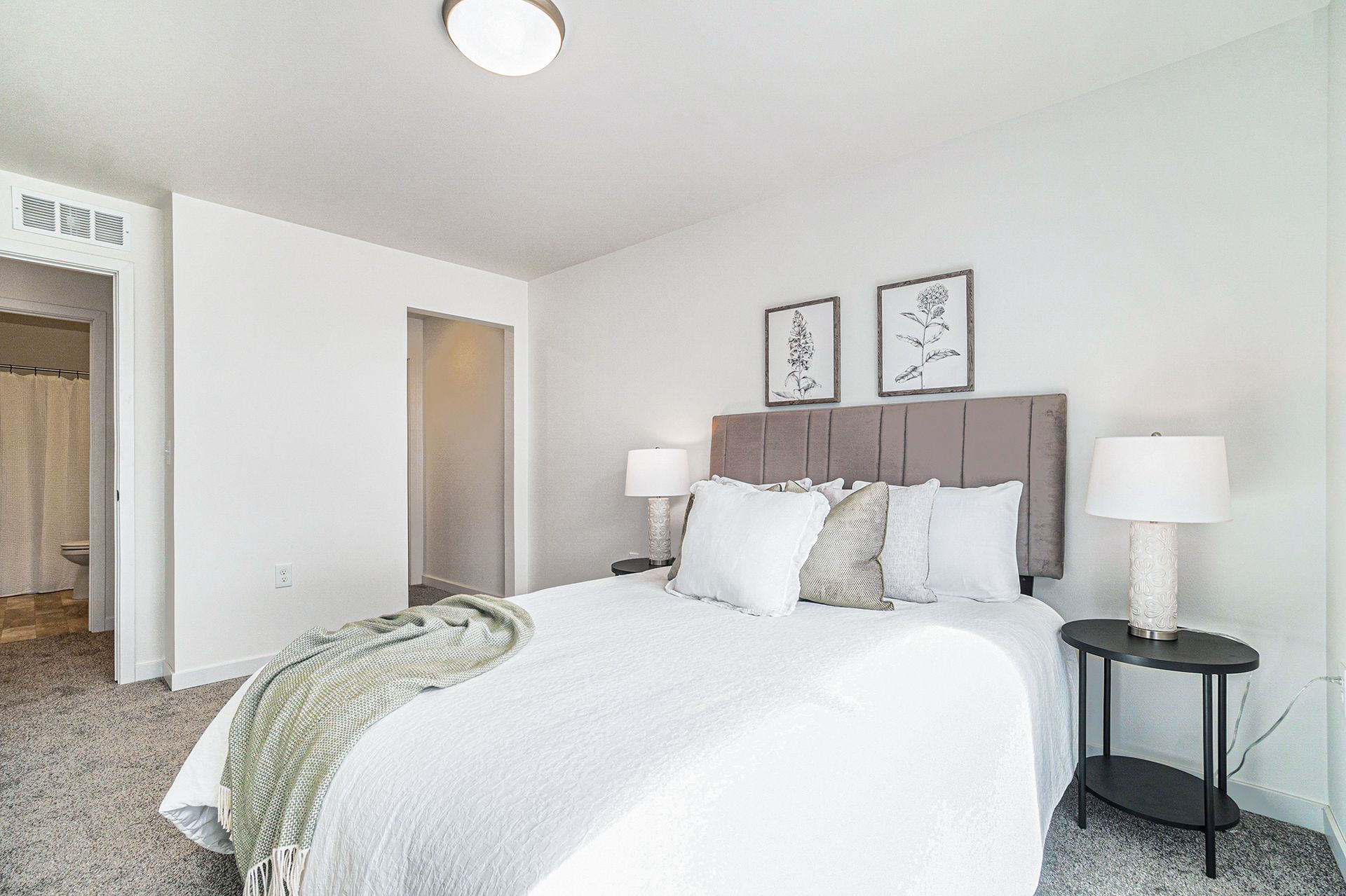 A bedroom with a bed , lamps , and a walk in closet.