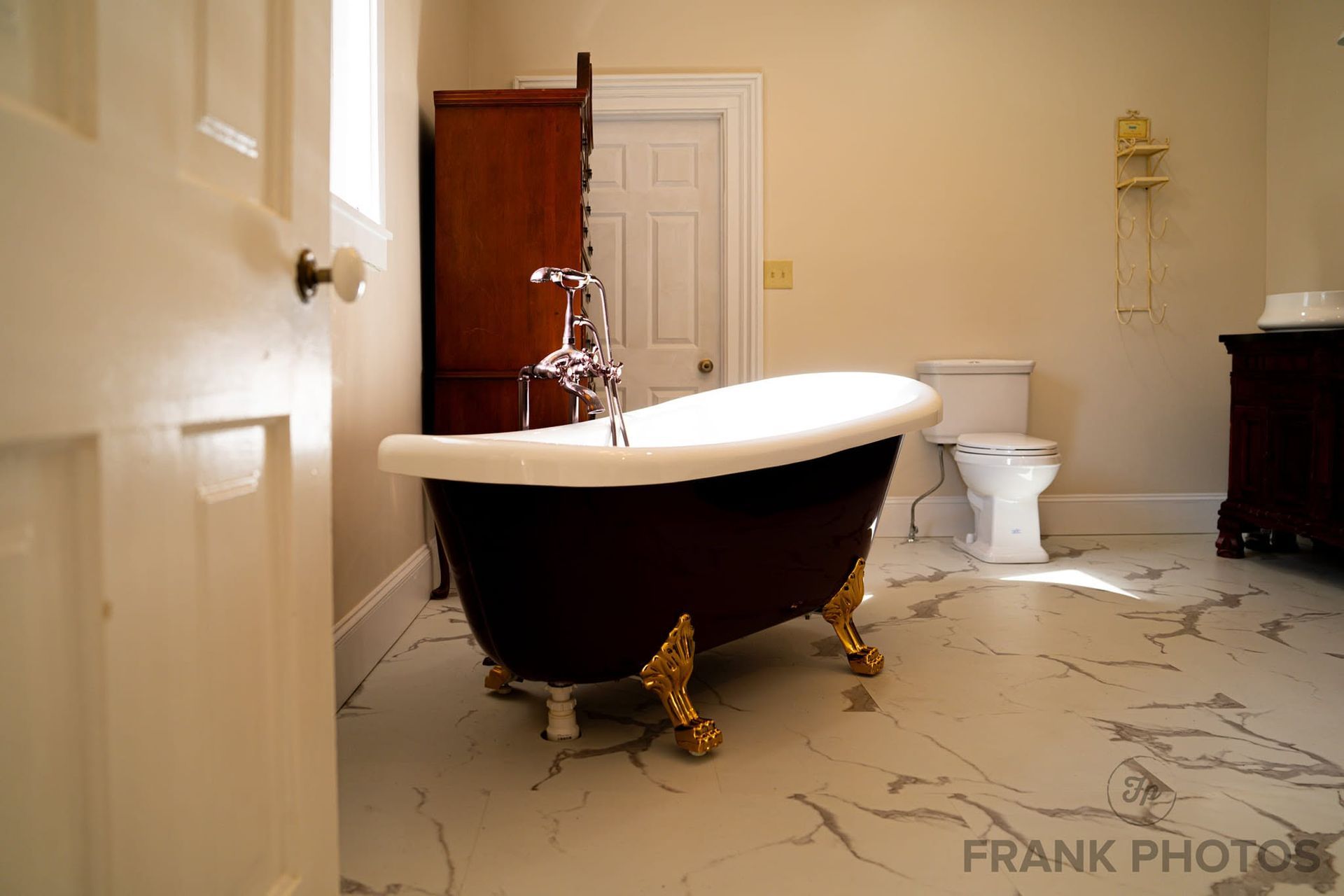 Bathroom with a black clawfoot tub and patterned tile floor