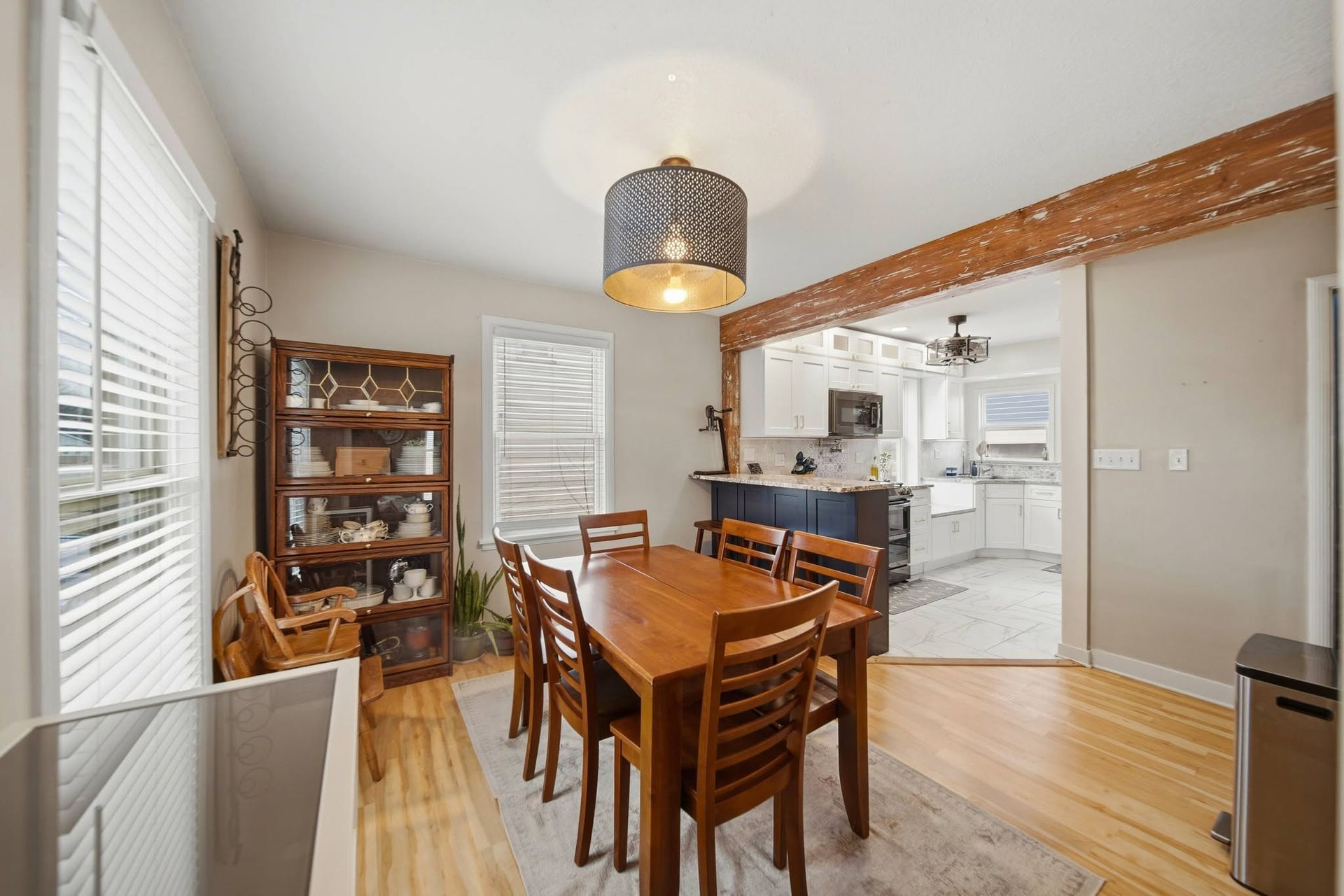 Dining room with a wood table, pendant light and exposed ceiling beam