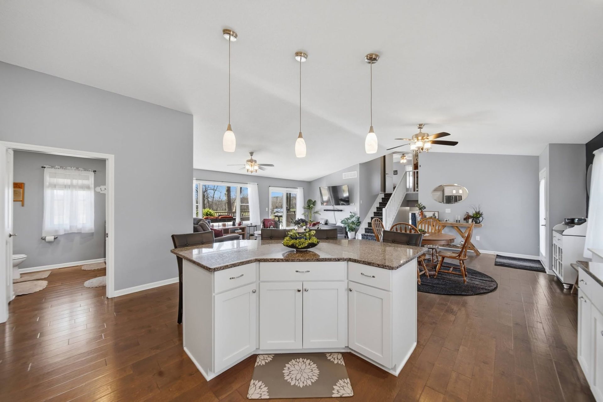 Kitchen island with pendant lights opening into a living area