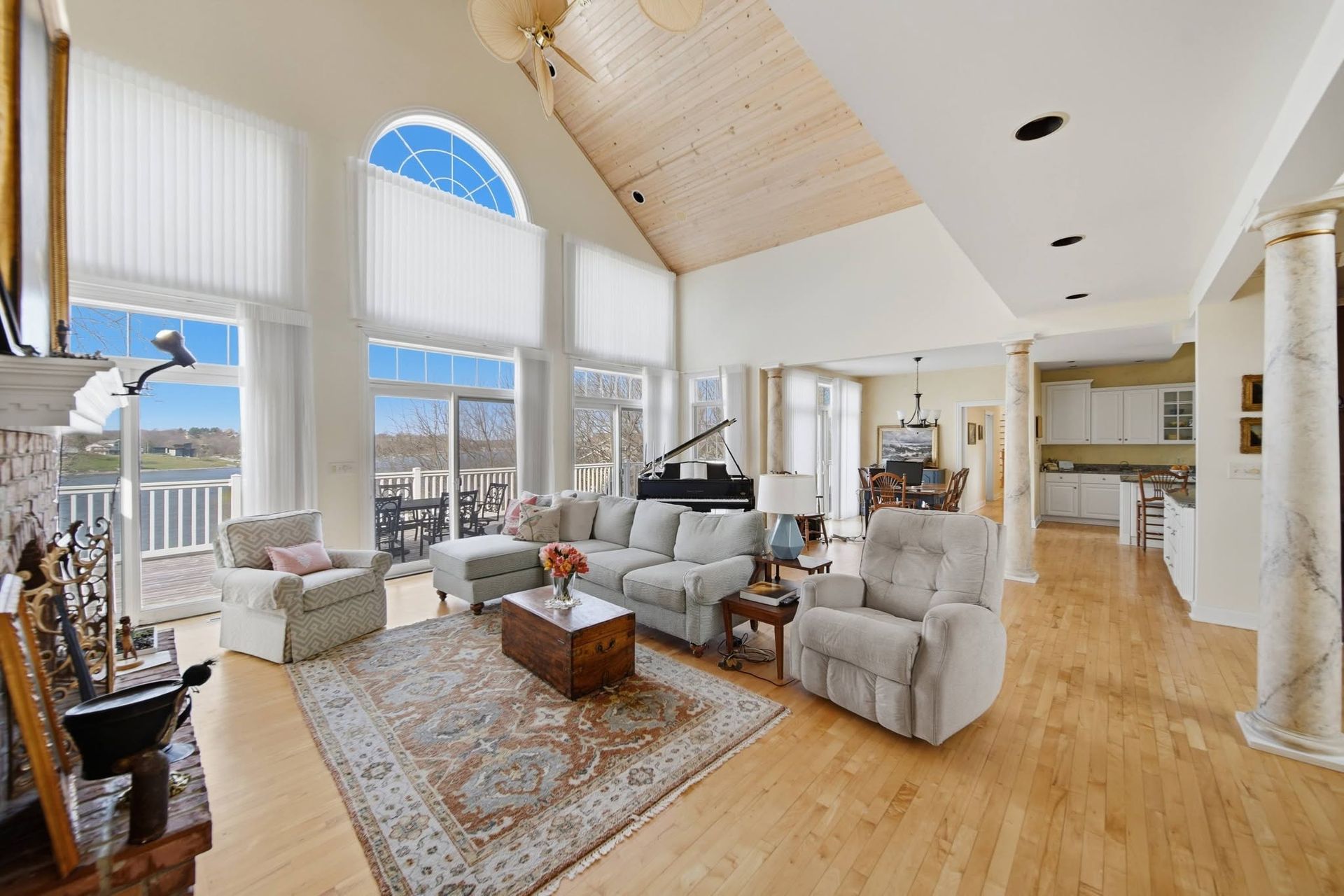 Vaulted living room with white seating and large arched windows