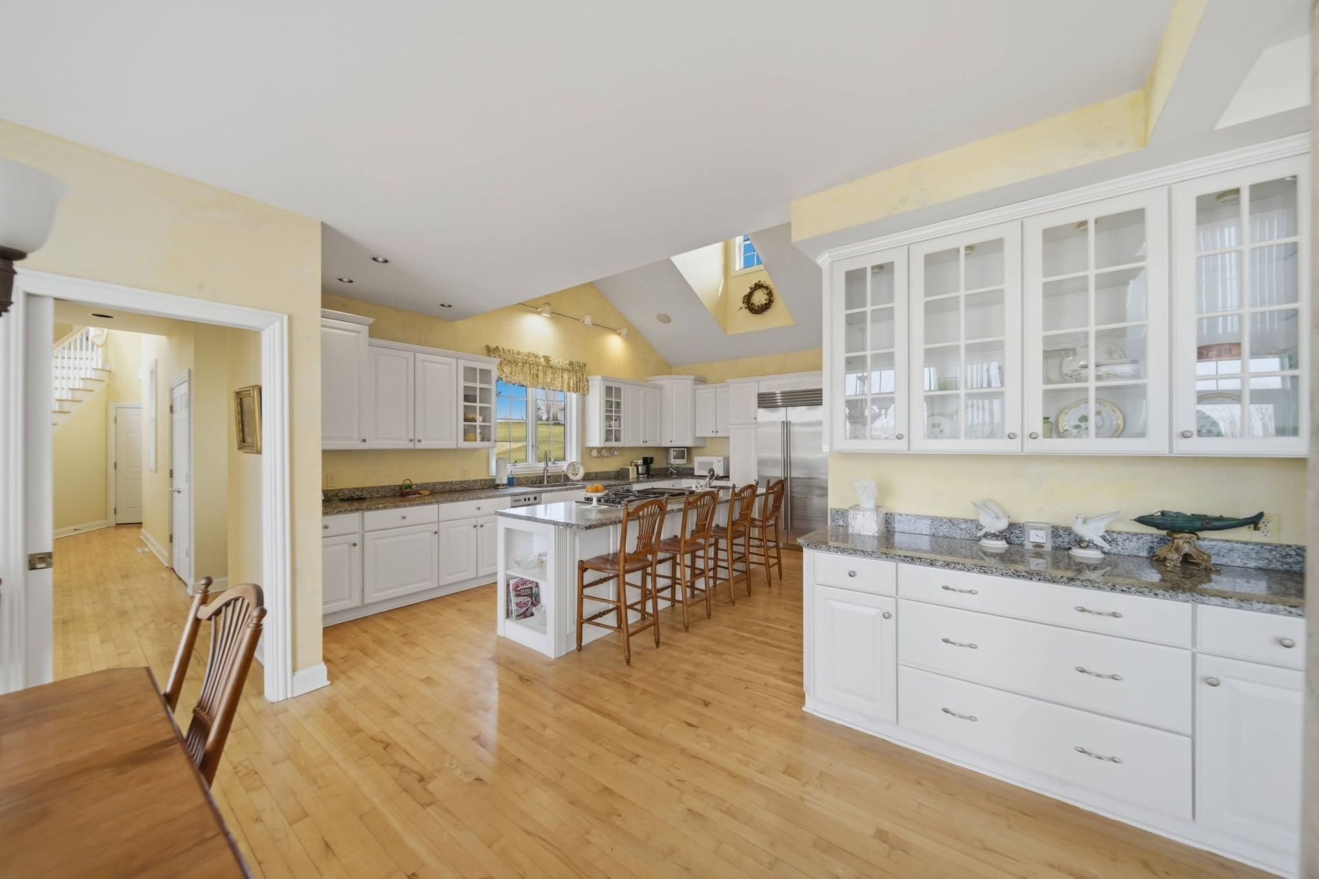 White kitchen with glass-front cabinets and island seating