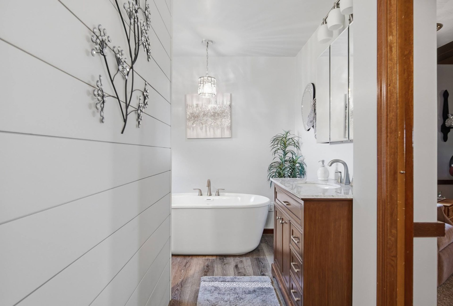 Bathroom with a freestanding white tub and wood vanity