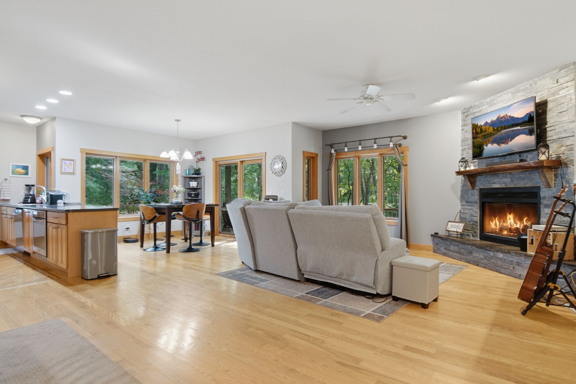 Open living area connecting the kitchen, dining space and stone fireplace