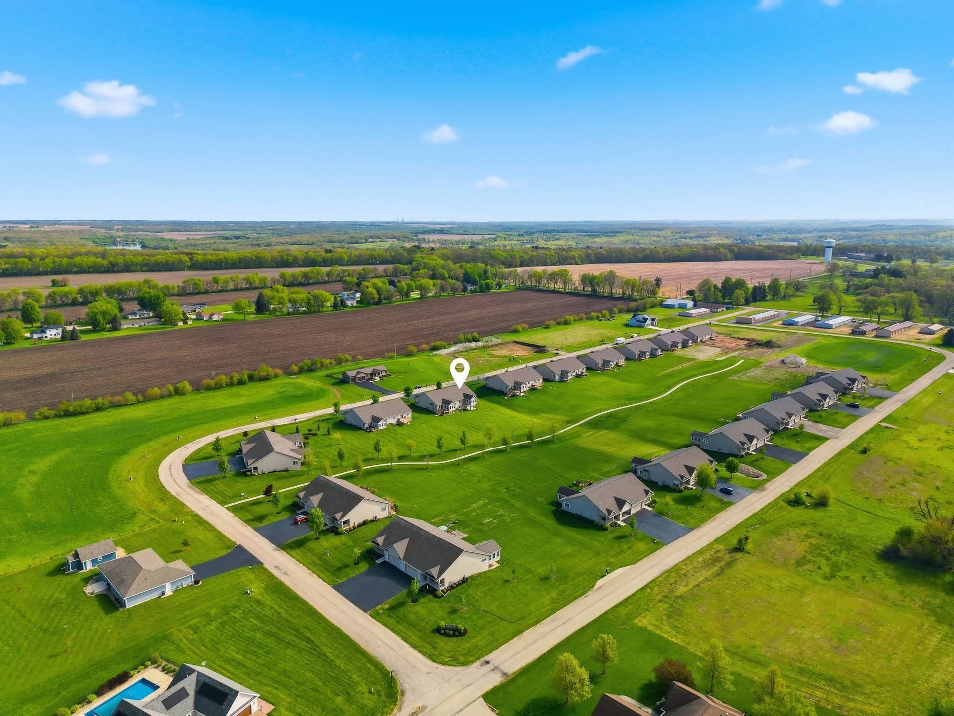 Drone view of a residential neighborhood surrounded by farmland