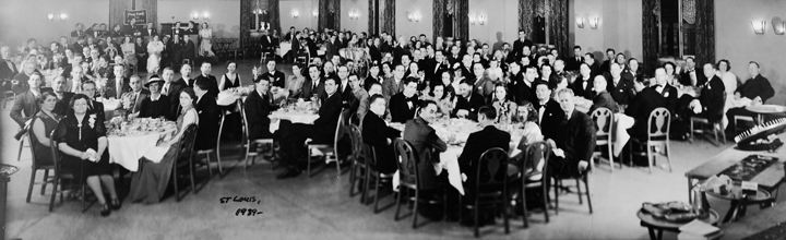 A large group of people are sitting at tables in a room.