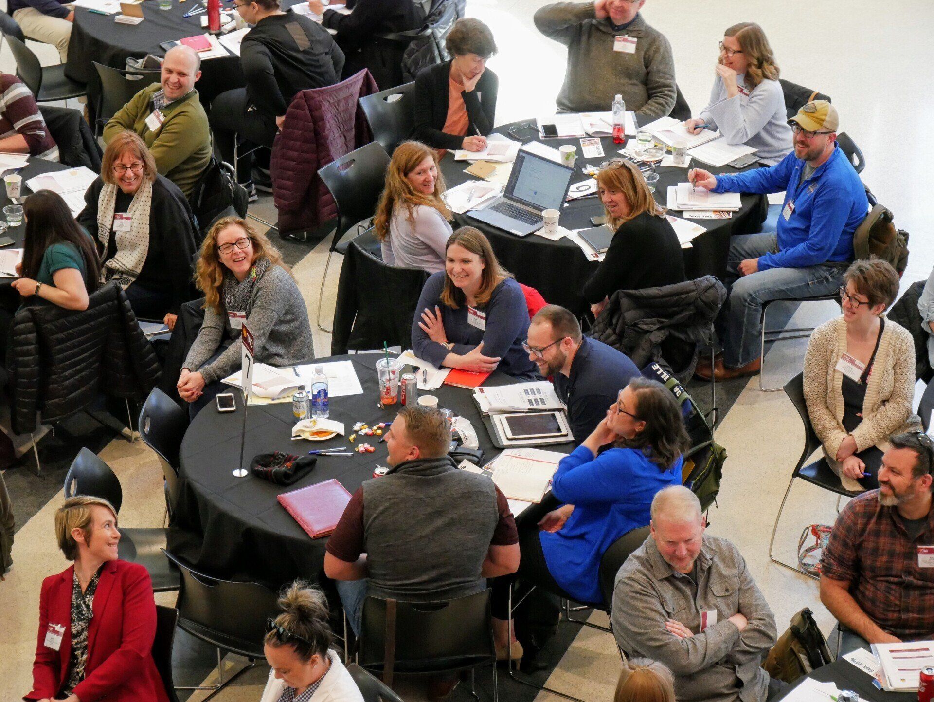 A large group of people are sitting at tables in a room.