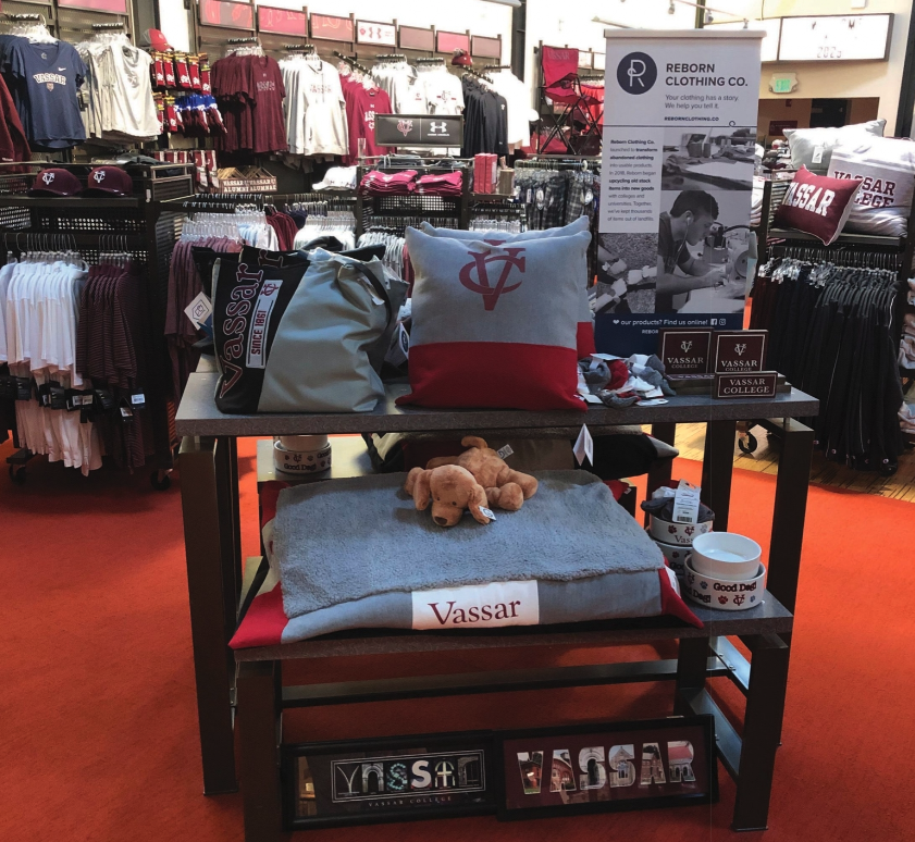 A table in a store with a pillow that says vassar on it