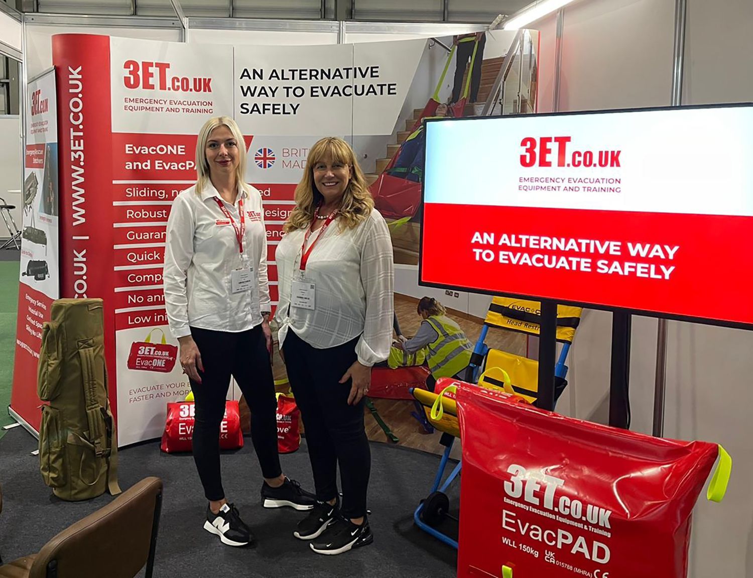 Two women at a trade show booth promoting