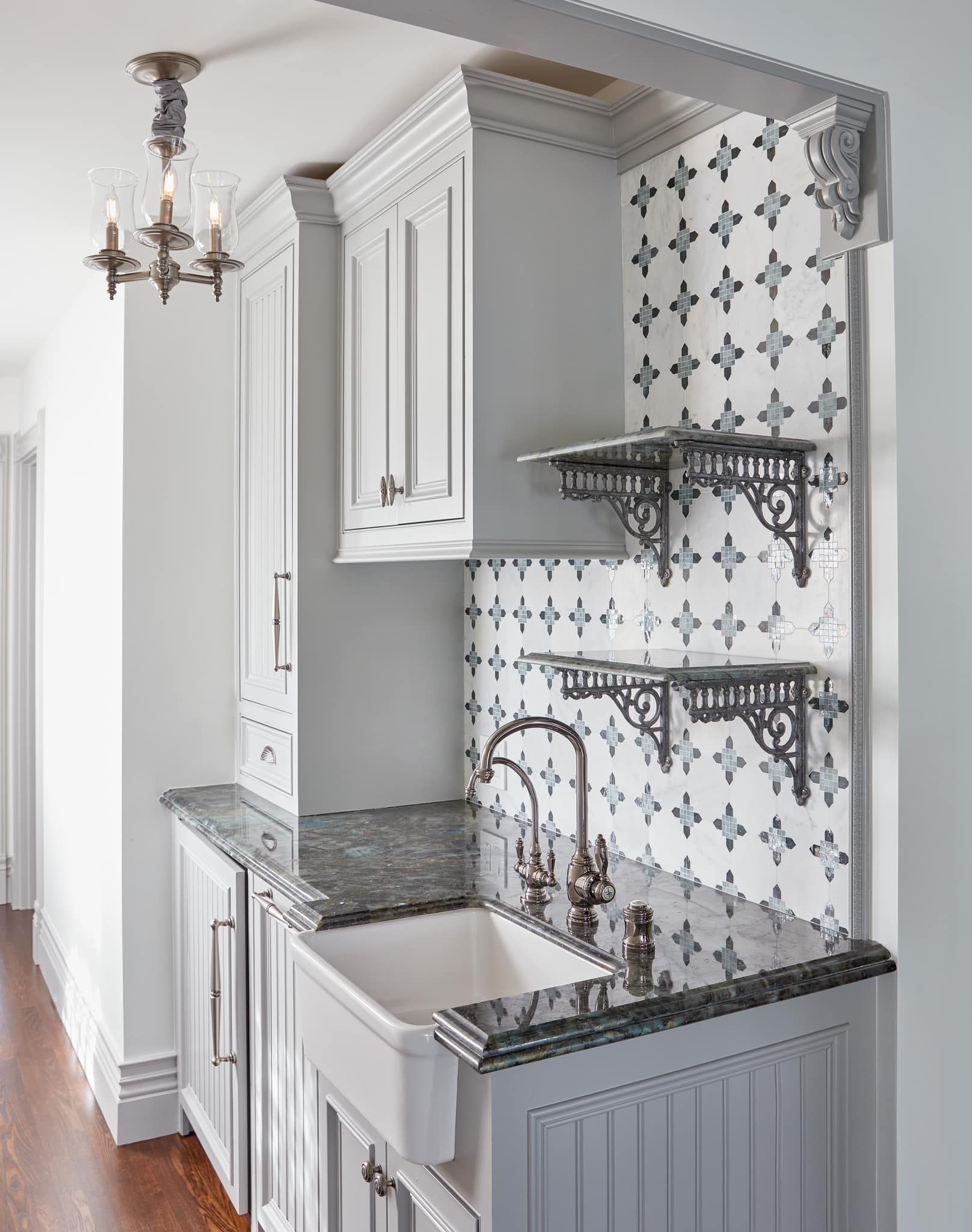 A kitchen with a sink and a chandelier hanging from the ceiling