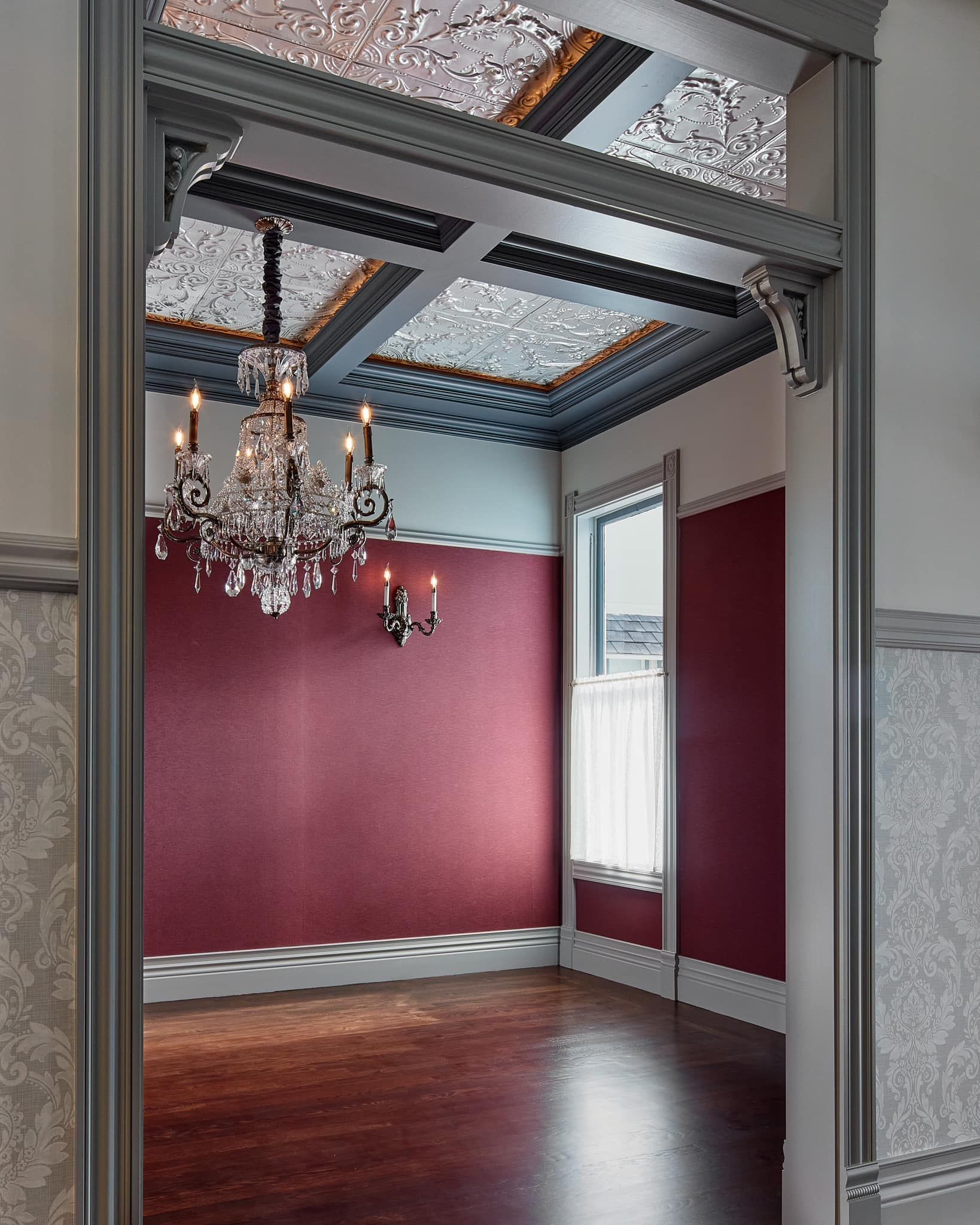 An empty room with a chandelier hanging from the ceiling