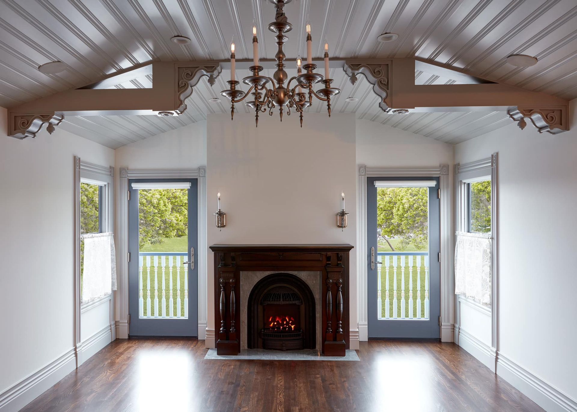 An empty room with a fireplace and a chandelier