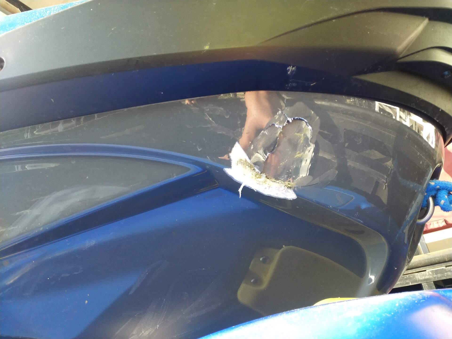 Blue car windshield with a large crack and chipped damage near the edge