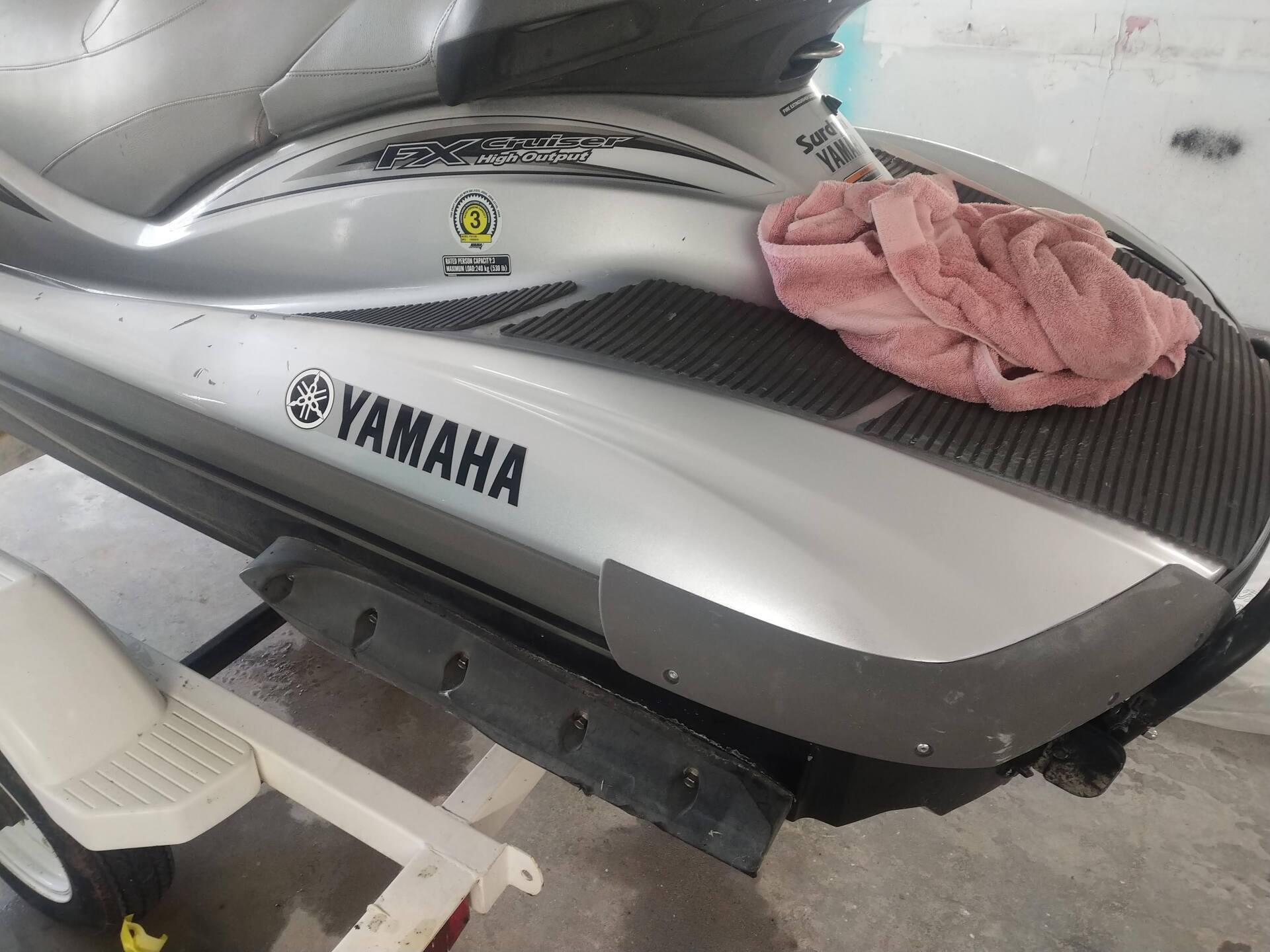 Silver Yamaha jet ski parked indoors with a pink cloth on the seat