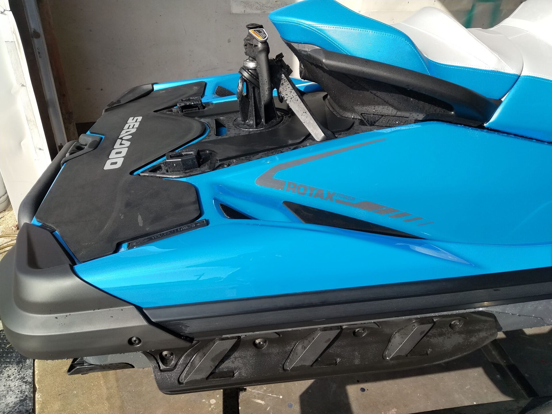 Blue and black jet ski with handlebars, shown in a garage or storage area