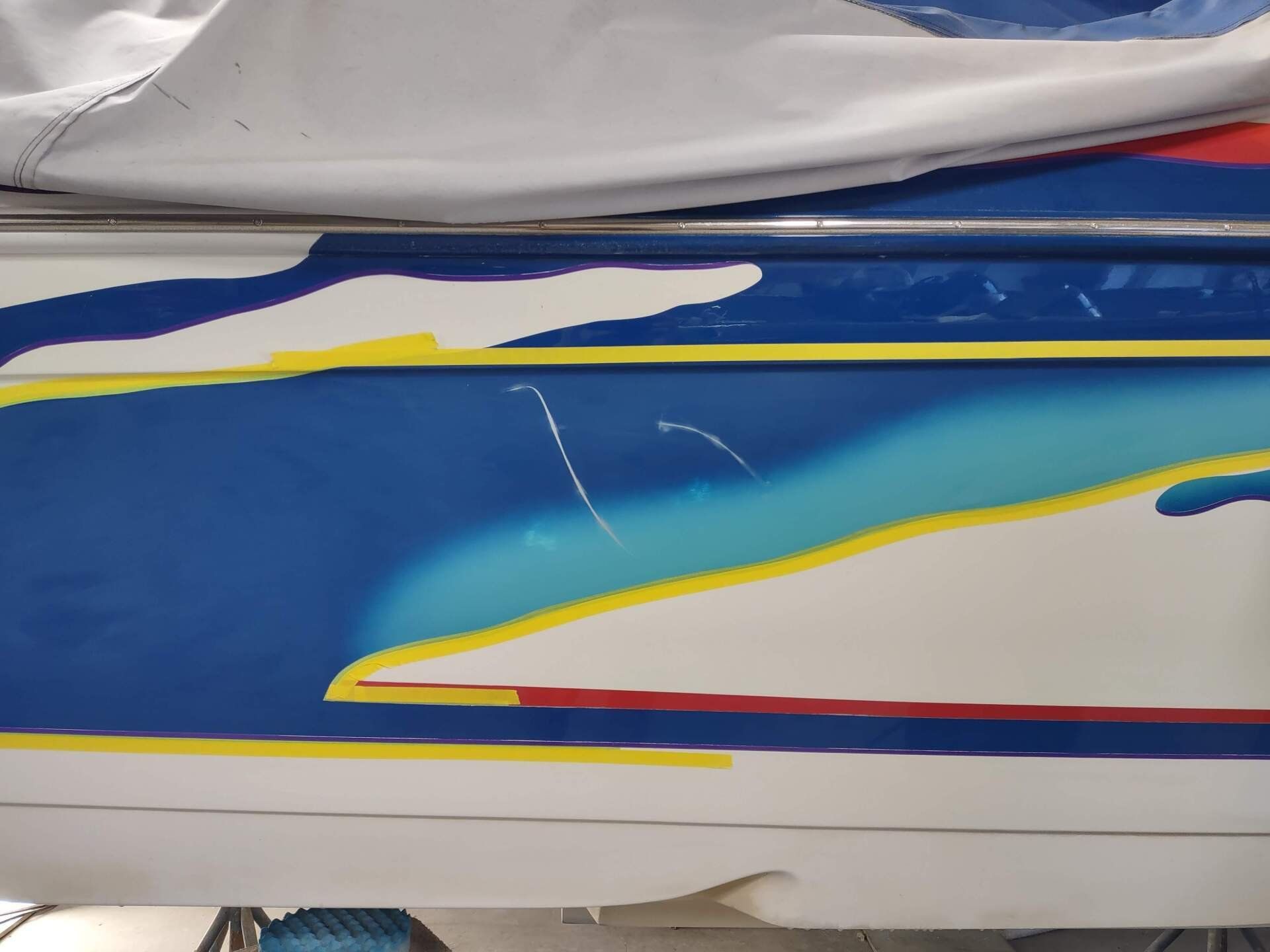 Blue and white racing car side panel with yellow and red accent stripes