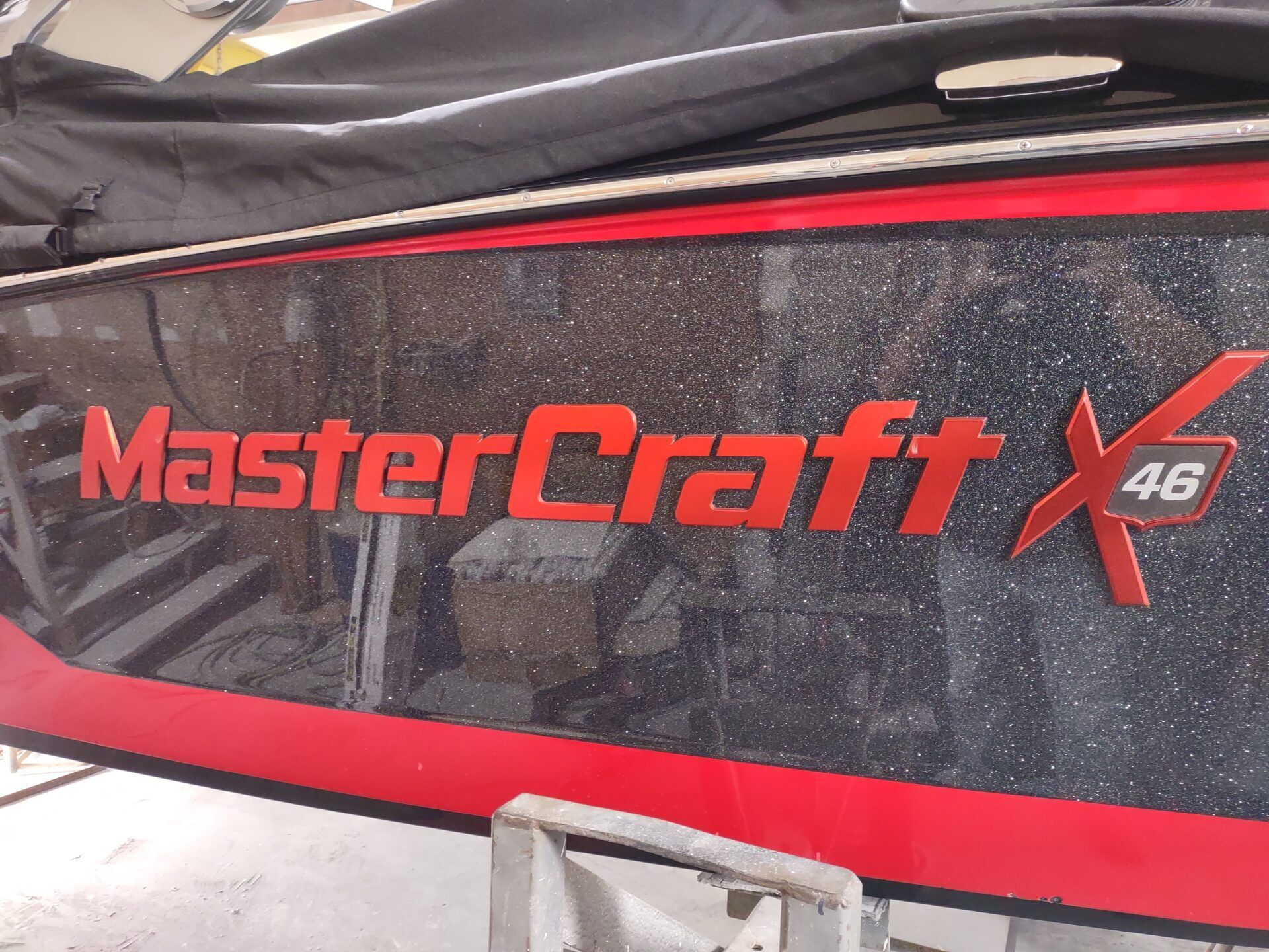Black and red MasterCraft X 46 boat cover with logo and water droplets