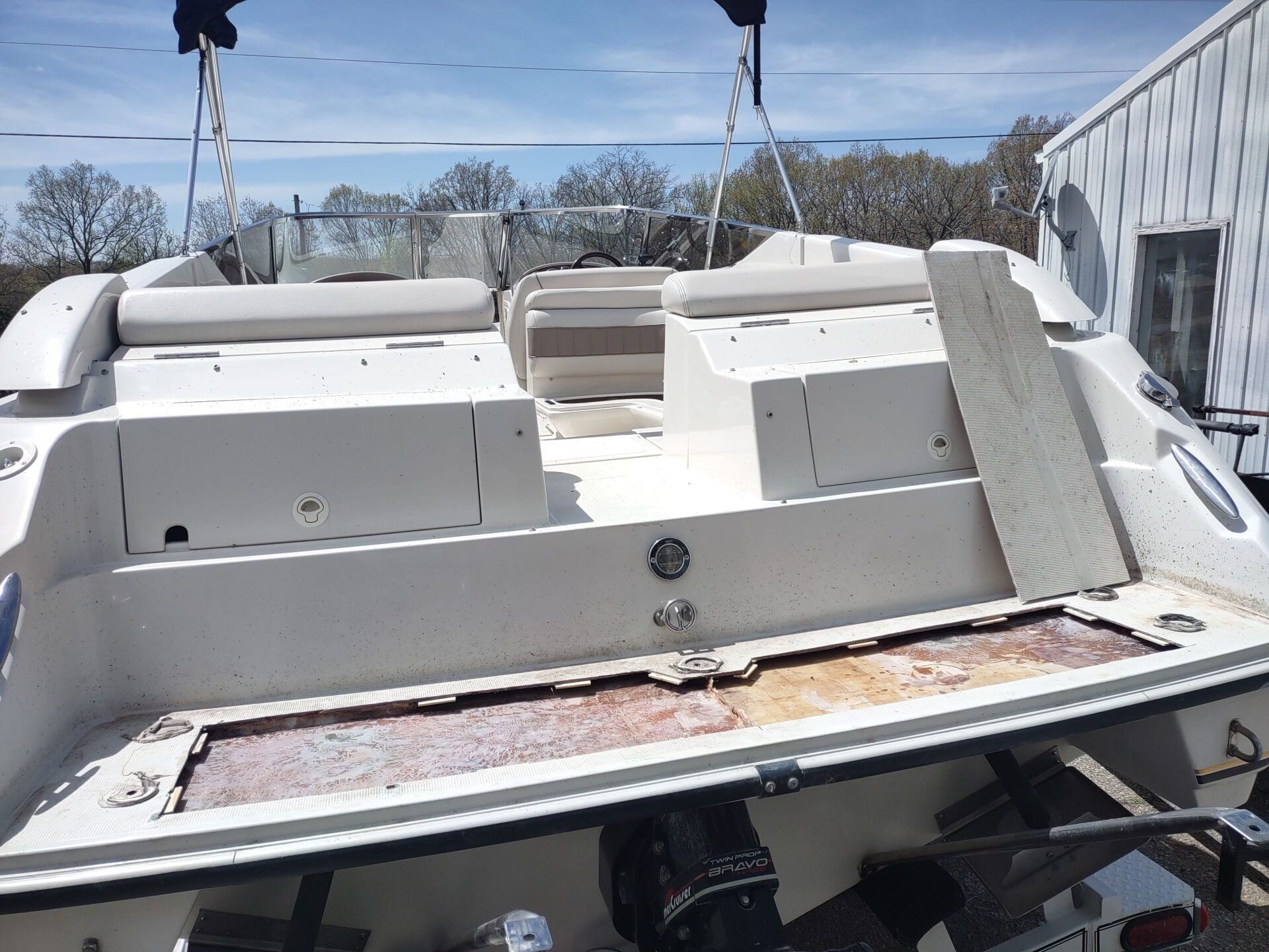 Damaged white boat cockpit with torn flooring and seats in a boatyard