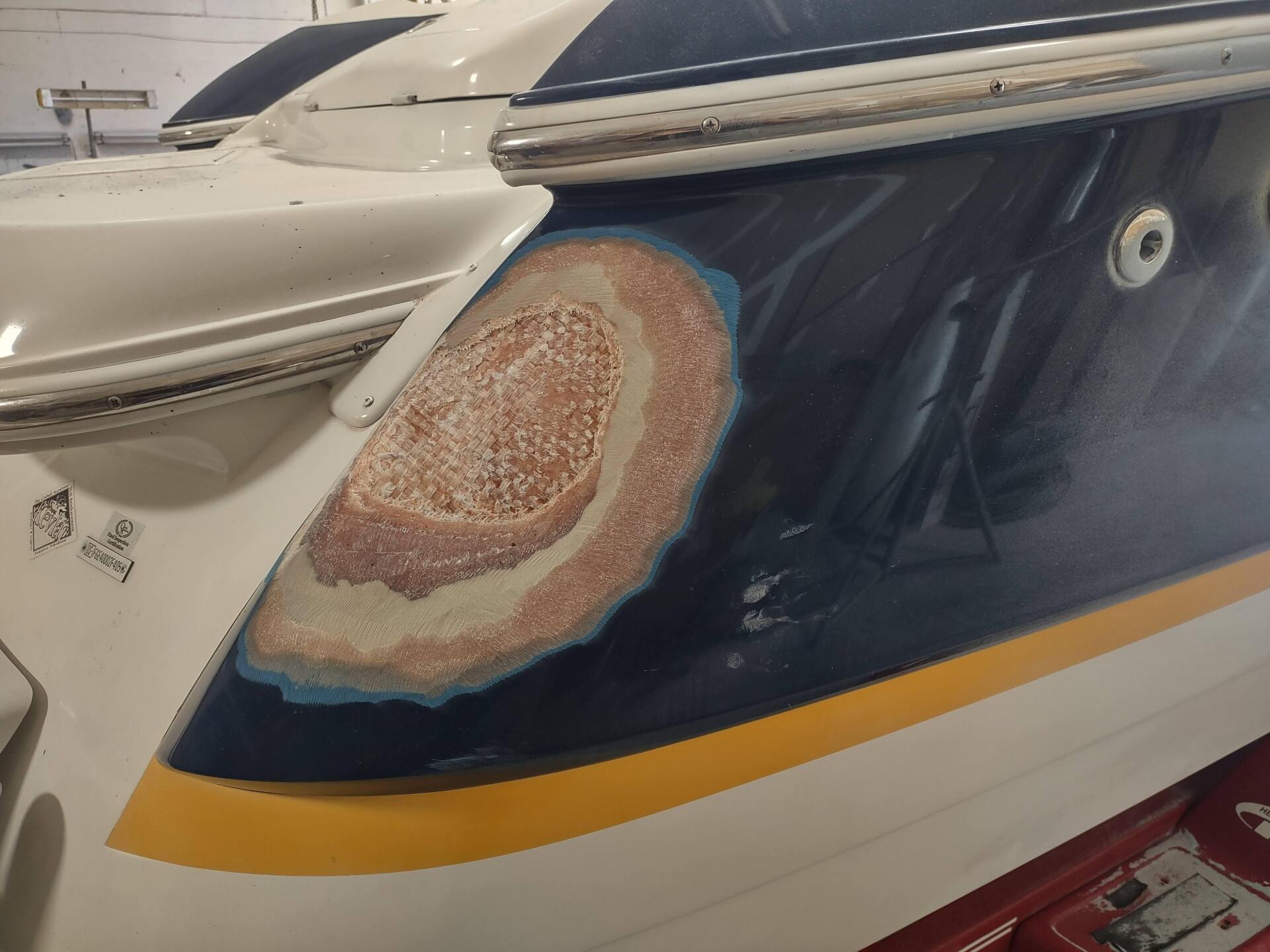 Boat hull with a large rust stain on dark blue paint near a white deck trim