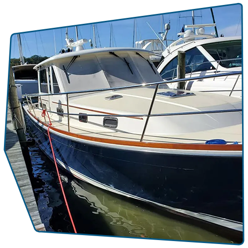 Blue and white motorboat docked at a marina with a wooden hull and tan trim.