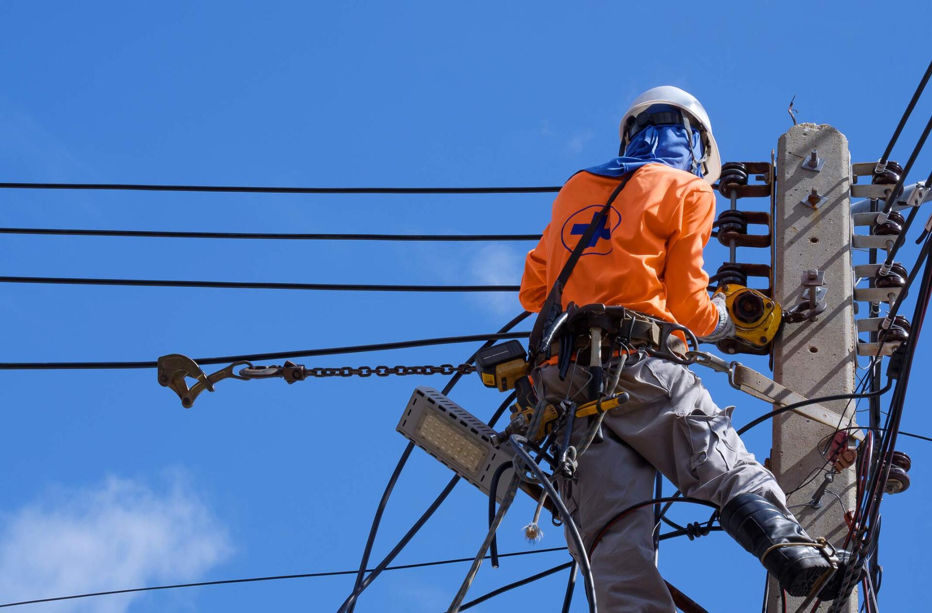 Electrician installing cable lines on electric pole | Wingham, NSW | KMF Electrical & Solar