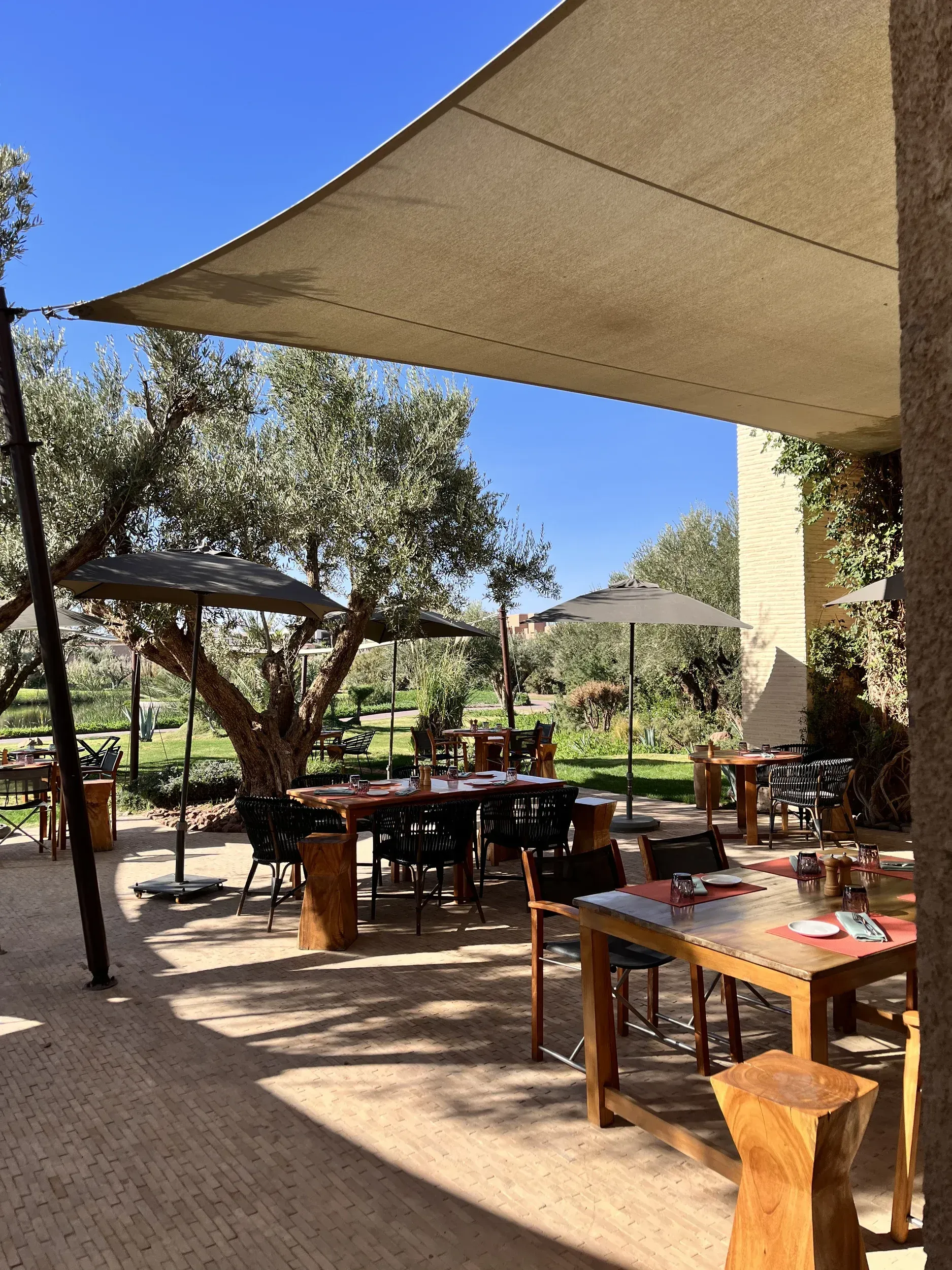 A restaurant with tables and chairs under an umbrella