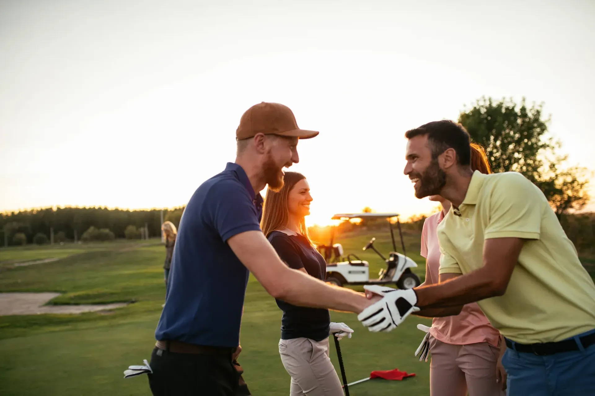 A group of people are shaking hands on a golf course.
