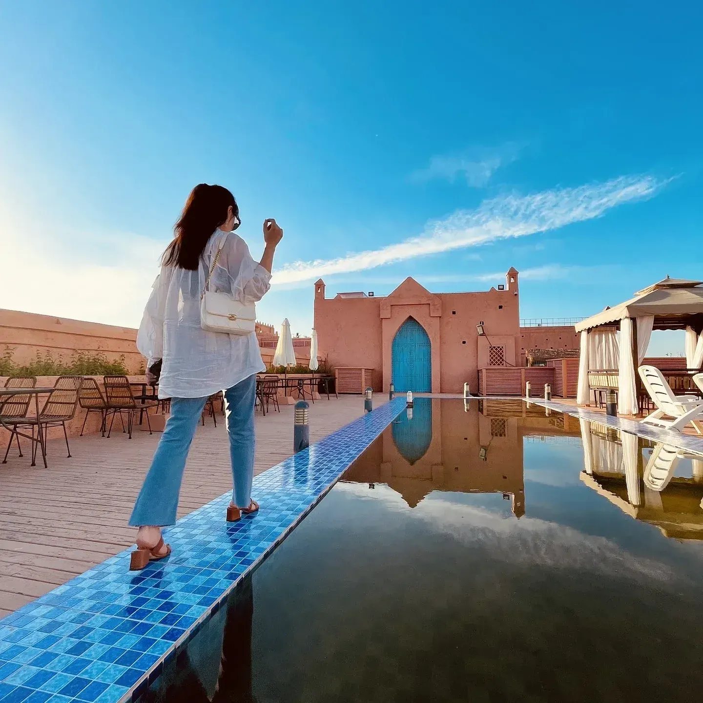 A woman is taking a picture of a building with her phone