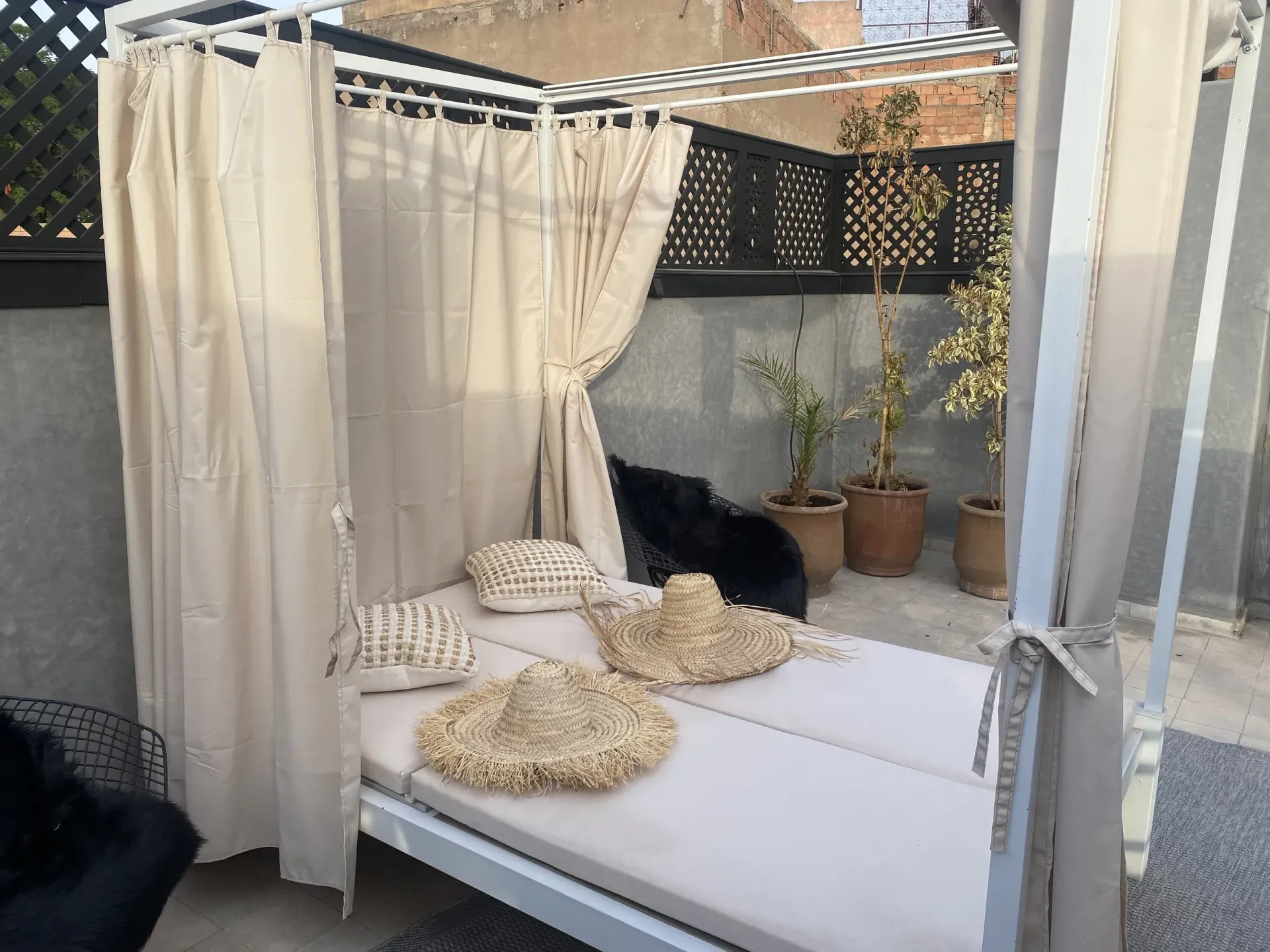 A canopy bed with straw hats and pillows on it