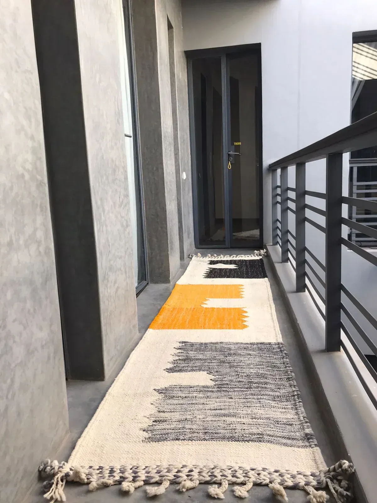 A narrow hallway with a rug on the floor