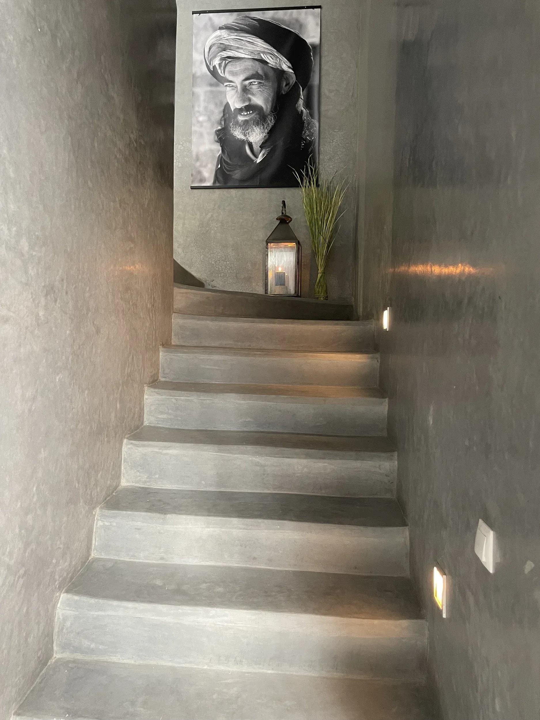A staircase with a picture of a man on the wall.