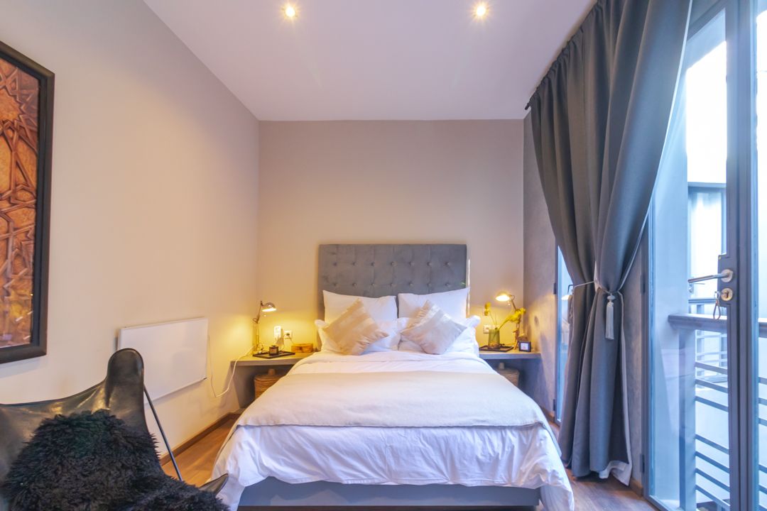 A bedroom with a large bed and a sliding glass door.
