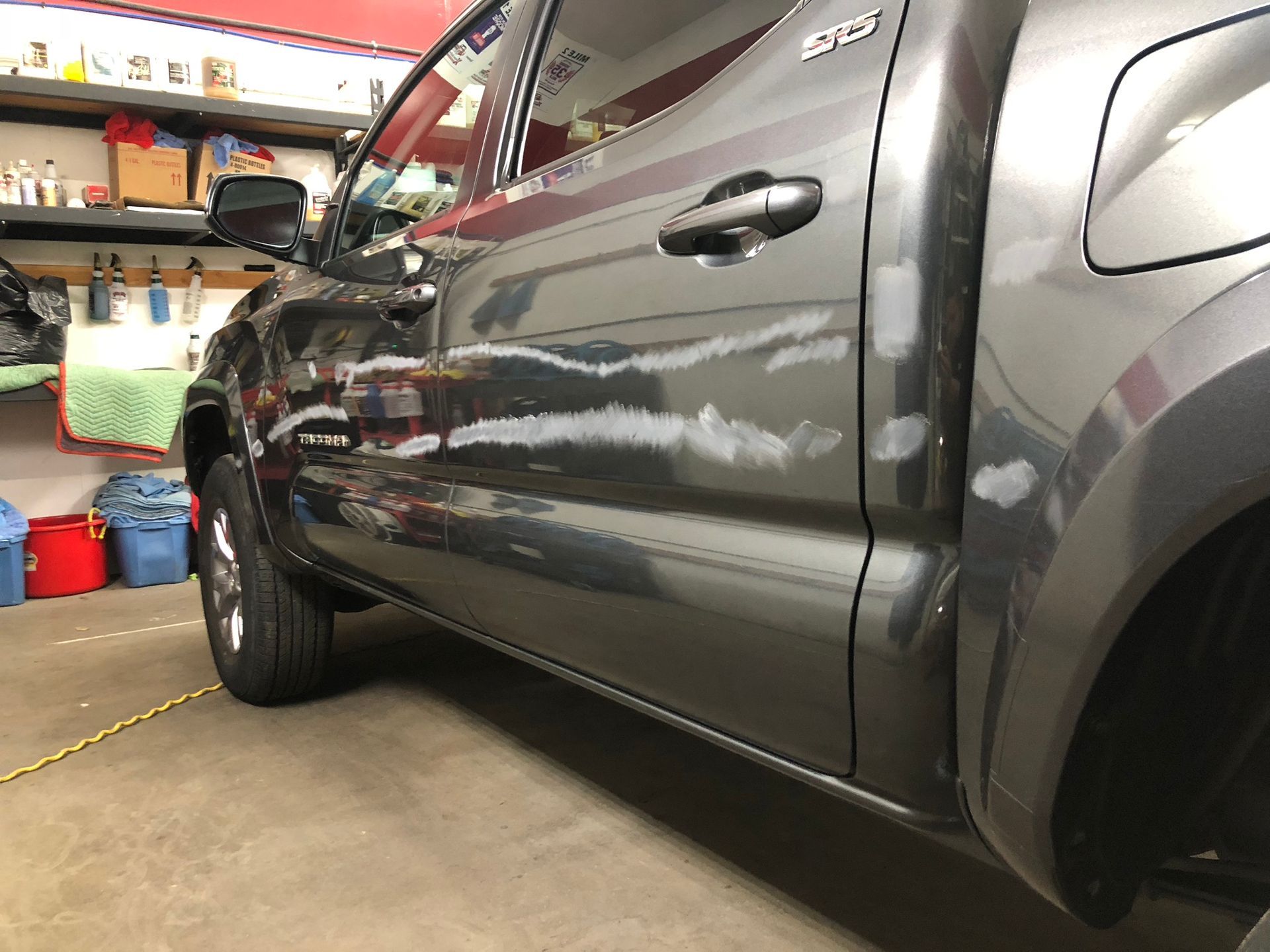 Dark gray pickup truck parked in a garage, seen from the side