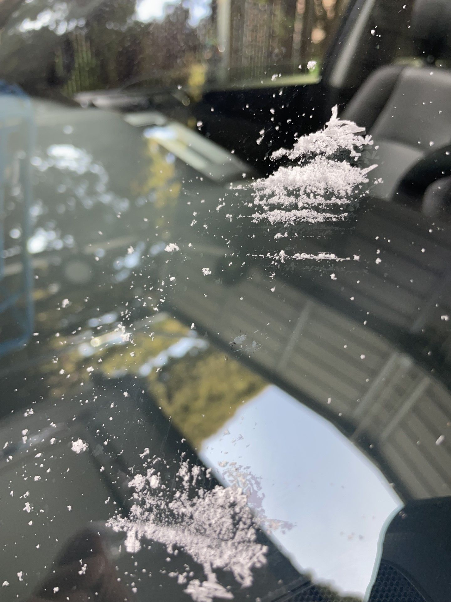 A close up of a car windshield with snow on it