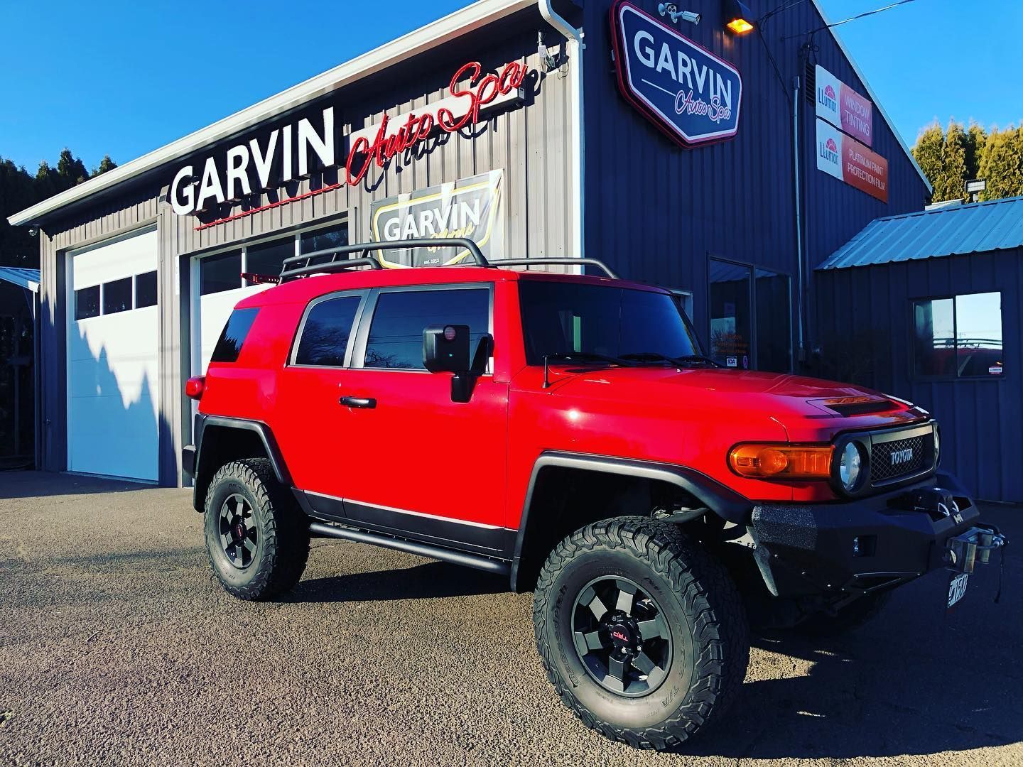 Red SUV parked outside Garvin dealership building on a sunny day