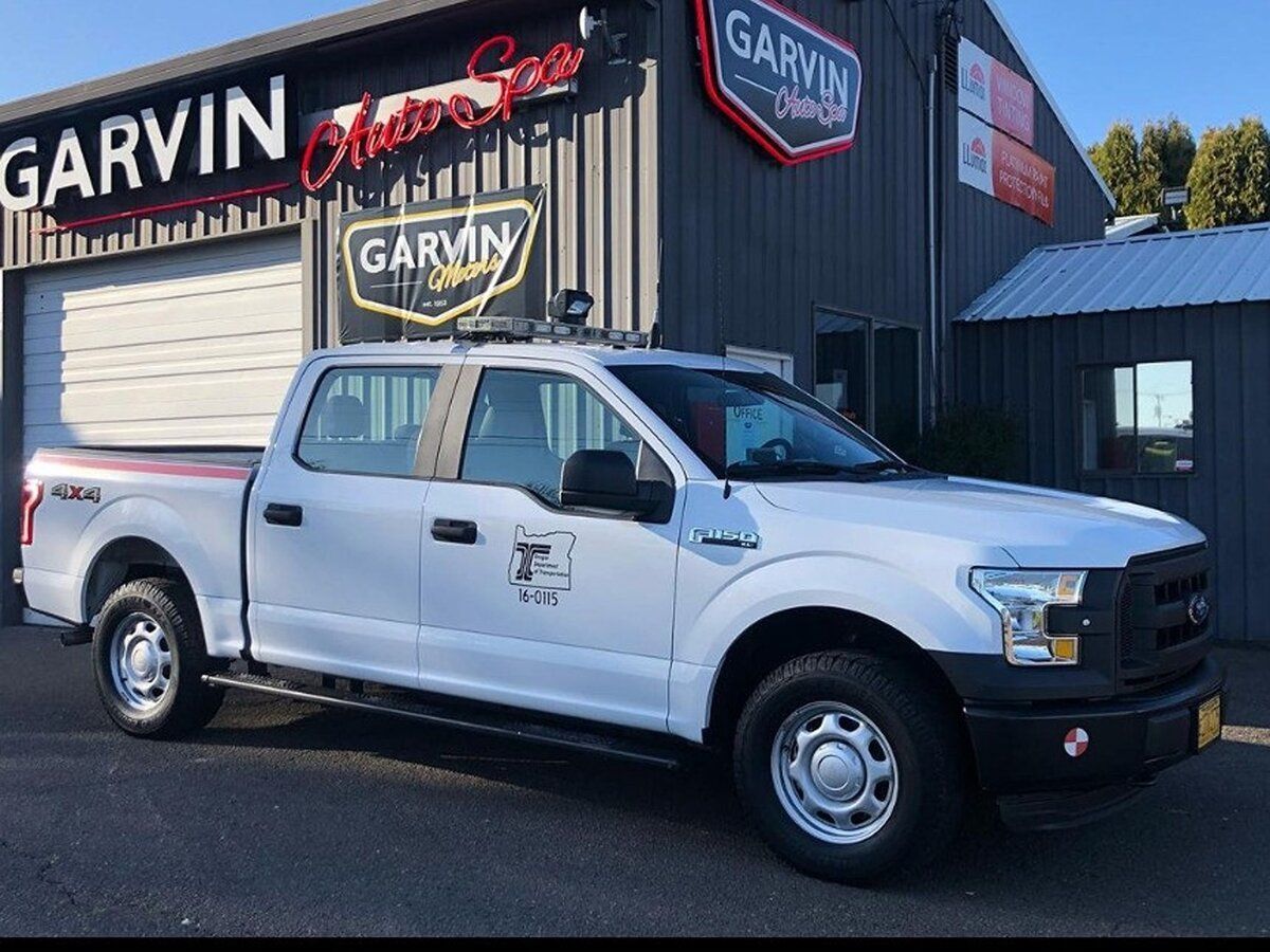 A white truck is parked in front of Garvin Auto Spa after being ceramic coated