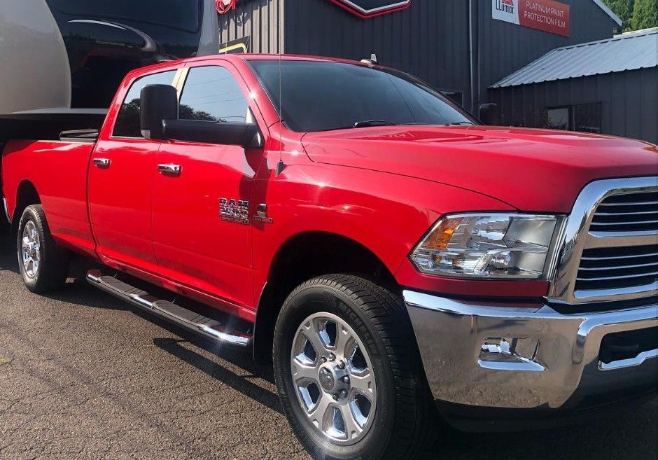 Red pickup truck parked outside a building on a sunny day