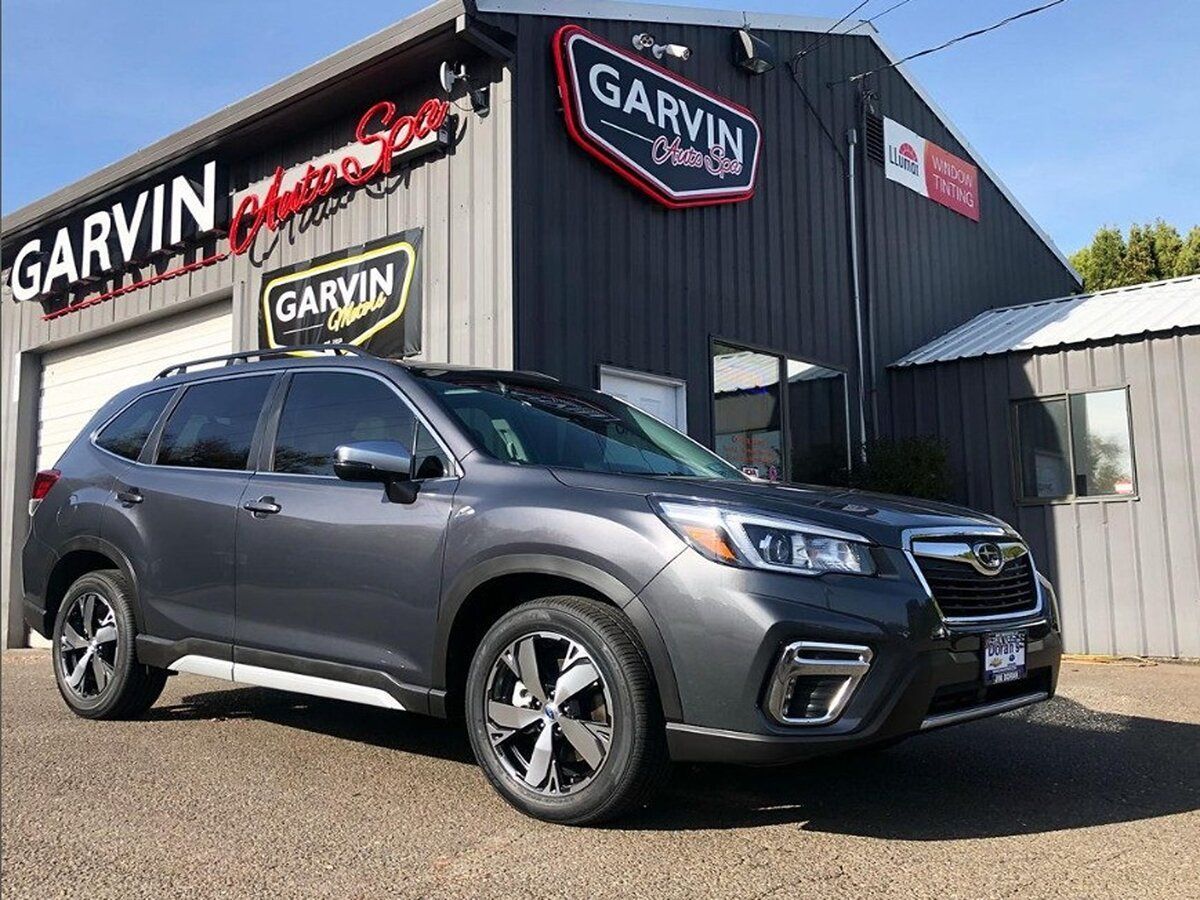 A subaru forester is parked in front of a garage having been ceramic coated
