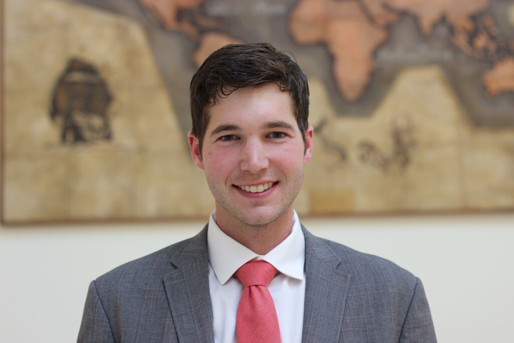 A man in a suit and tie is smiling for the camera.