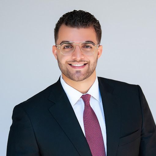 A man in a suit and tie is smiling for the camera.