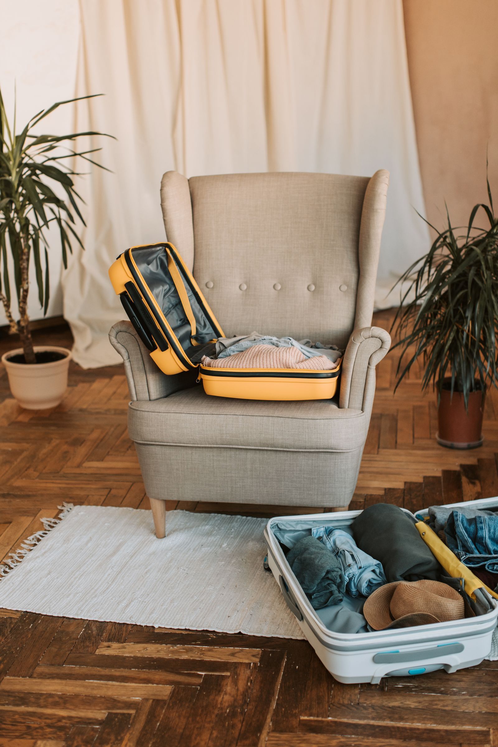 A packed suitcase standing beside a chair