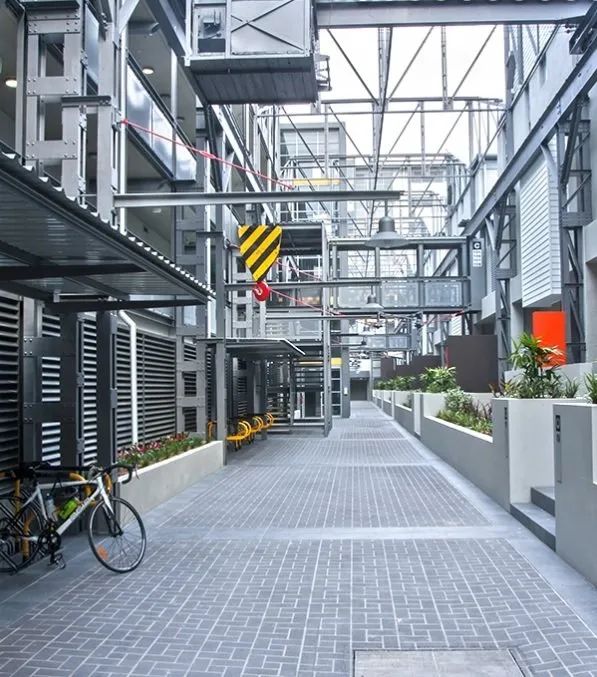 Modern industrial walkway with metal walkways, gray paving, and a bicycle on the left