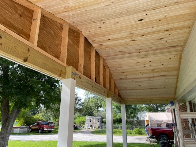A section of a building with a metal gutter and downspout over horizontal wooden siding. A section of a building with a metal gutter and downspout over horizontal wooden siding.